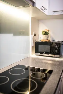 a kitchen with a microwave and a stove top oven at KL Sentral Bangsar Suites EST BY PSM LUXURY SUITES in Kuala Lumpur