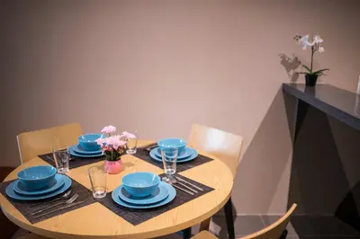 a wooden table with blue dishes and flowers on it at KL Sentral Bangsar Suites (EST) by Luxury Suites Asia in Kuala Lumpur