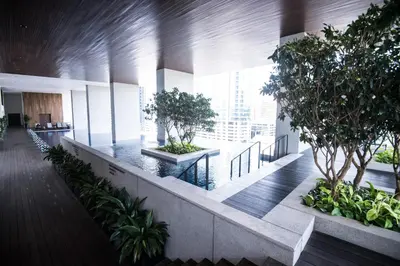 an office building hallway with trees and plants at KL Sentral Bangsar Suites (EST) by Luxury Suites Asia in Kuala Lumpur