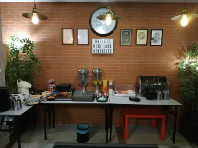 a table with a clock on a brick wall at Hotel Twenty 8B in Kuala Lumpur