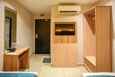 a room with a bathroom with a sink and a door at Alaxis Hotel in Kuala Lumpur