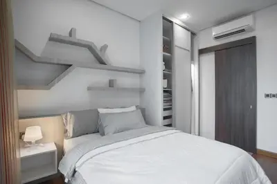 a bedroom with a white bed and shelves at Soho Suites KLCC by 21 Century travel in Kuala Lumpur