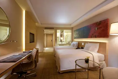 a hotel room with two beds and a desk at DoubleTree By Hilton Kuala Lumpur in Kuala Lumpur