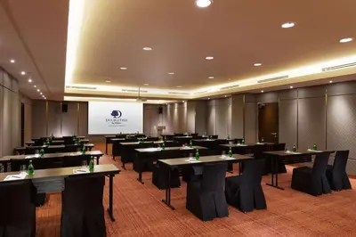 a conference room with tables and chairs and a screen at DoubleTree By Hilton Kuala Lumpur in Kuala Lumpur