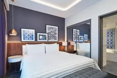a bedroom with a large white bed and a bathroom at Le Méridien Kuala Lumpur in Kuala Lumpur
