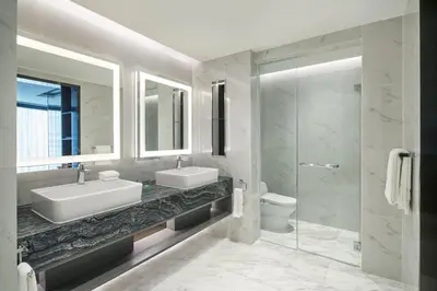 a bathroom with a sink and a toilet and a mirror at Le Méridien Kuala Lumpur in Kuala Lumpur