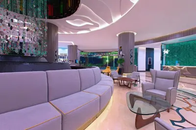 a living room with a large couch and chairs at Le Méridien Kuala Lumpur in Kuala Lumpur