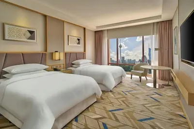 two beds in a hotel room with a view at Sheraton Imperial Kuala Lumpur Hotel in Kuala Lumpur