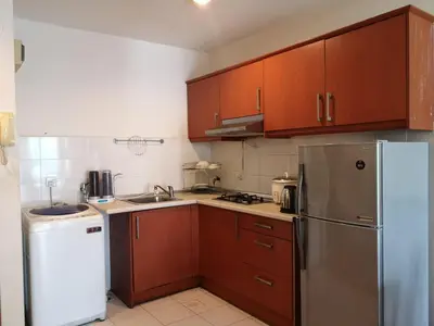 a kitchen with wooden cabinets and a stainless steel refrigerator at Maytower Service Suite - Masjid India in Kuala Lumpur