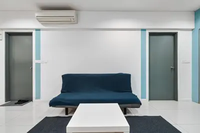 a blue couch in a room with two doors at Summer Suites KLCC Apartments by soulasia in Kuala Lumpur