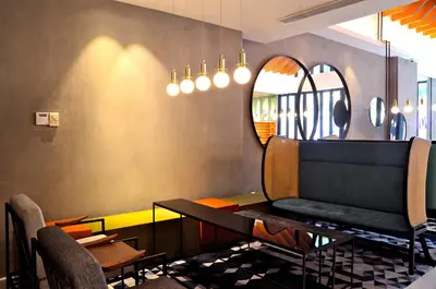 a dining room with a table and a mirror at MOV Hotel Kuala Lumpur in Kuala Lumpur