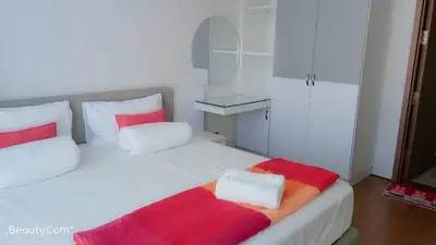 a bedroom with a white bed with red and white pillows at Soho Suites KLCC by LX Suites 2 in Kuala Lumpur