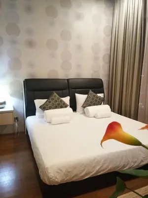 a bedroom with a bed with white sheets and pillows at Soho Suites KLCC by LX Suites 2 in Kuala Lumpur