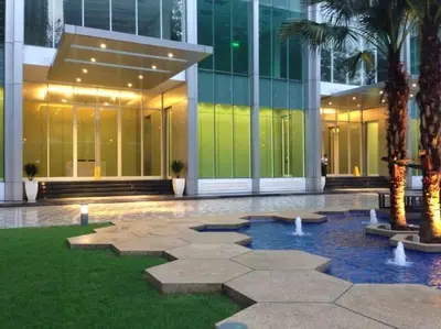 a building with a courtyard with palm trees in front of it at Soho Suites KLCC by LX Suites 2 in Kuala Lumpur