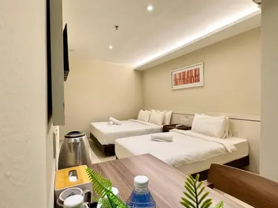 a hotel room with two beds and a table at Kingston Hotel 1 - Bukit Bintang in Kuala Lumpur