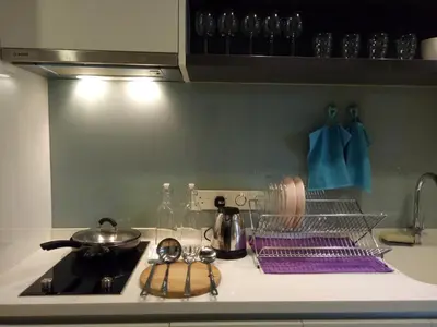 a kitchen counter with a stove with purple towels at KL Platinum KLCC By Hive KL in Kuala Lumpur