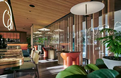 a restaurant with tables and chairs and potted plants at PARKROYAL COLLECTION Kuala Lumpur in Kuala Lumpur