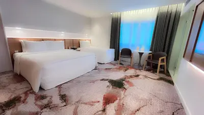 a hotel room with a large white bed and a table at The Federal Kuala Lumpur in Kuala Lumpur