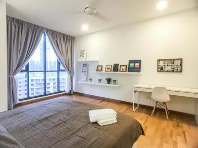a bedroom with a bed and a desk and a window at KL Gateway Residency in Kuala Lumpur
