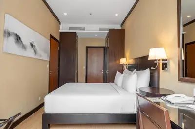 a hotel room with a bed and a desk at Micasa All Suites Hotel in Kuala Lumpur