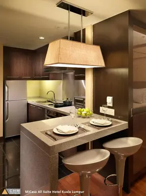 a kitchen with a large island with two bar stools at Micasa All Suites Hotel in Kuala Lumpur