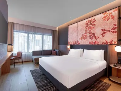 a hotel room with a bed and a couch at Grand Mercure Kuala Lumpur Bukit Bintang in Kuala Lumpur
