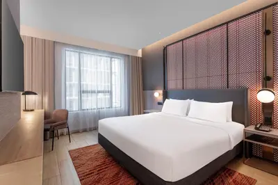 a bedroom with a large white bed and a desk at Grand Mercure Kuala Lumpur Bukit Bintang in Kuala Lumpur