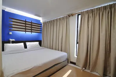 a bedroom with a white bed and a blue wall at Hotel China Town 2 in Kuala Lumpur