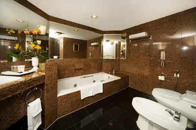 a bathroom with a bath tub and two sinks at Grand Millennium Kuala Lumpur in Kuala Lumpur