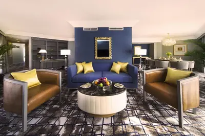 a living room with a blue couch and two chairs at Grand Millennium Kuala Lumpur in Kuala Lumpur