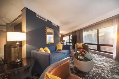 a living room with a blue couch in a hotel room at Grand Millennium Kuala Lumpur in Kuala Lumpur