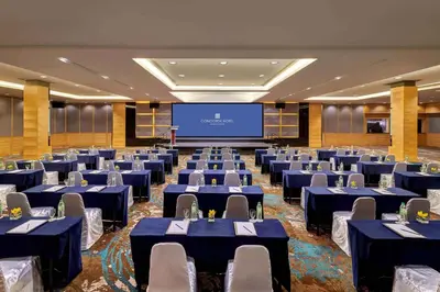 a conference room with blue tables and chairs and a screen at Concorde Hotel Kuala Lumpur in Kuala Lumpur