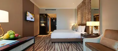 a hotel room with a bed and a living room at Dorsett Kuala Lumpur in Kuala Lumpur