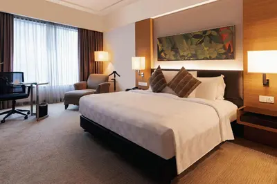 a hotel room with a large bed and a desk at Impiana KLCC Hotel in Kuala Lumpur