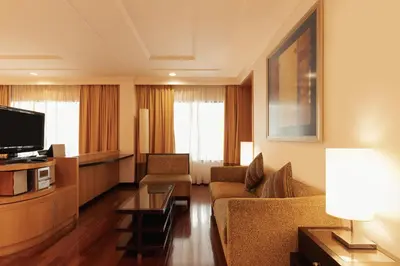 a living room with a couch and a tv at Impiana KLCC Hotel in Kuala Lumpur