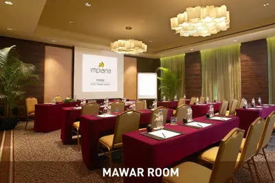 a conference room with tables and chairs and a screen at Impiana KLCC Hotel in Kuala Lumpur