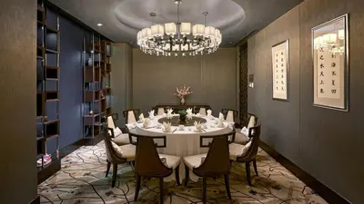 a dining room with a table and chairs and a chandelier at InterContinental Kuala Lumpur by IHG in Kuala Lumpur