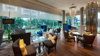 a living room with couches and tables and chairs at InterContinental Kuala Lumpur by IHG in Kuala Lumpur