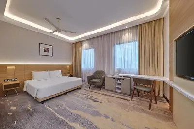 a bedroom with a bed and a desk and a television at Cititel Mid Valley in Kuala Lumpur