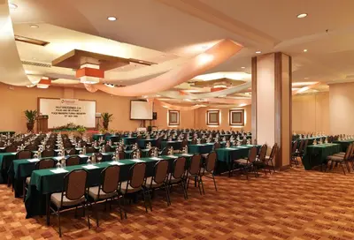 a banquet hall with green tables and chairs at Cititel Mid Valley in Kuala Lumpur