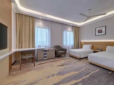 a hotel room with two beds and a desk and a tv at Cititel Mid Valley in Kuala Lumpur