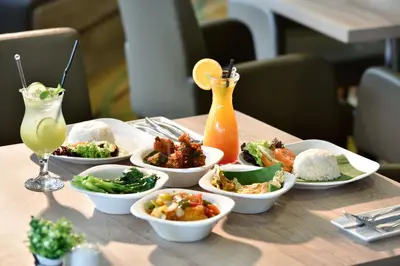 a table with bowls of food and a drink at St Giles Boulevard in Kuala Lumpur