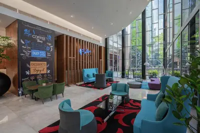 a lobby with blue chairs and tables and windows at St Giles Boulevard in Kuala Lumpur