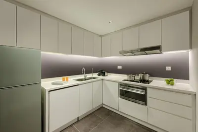 a kitchen with white cabinets and a sink at Ascott Kuala Lumpur in Kuala Lumpur