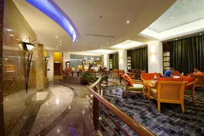 a lobby with a restaurant with tables and chairs at Hotel Royal Kuala Lumpur in Kuala Lumpur