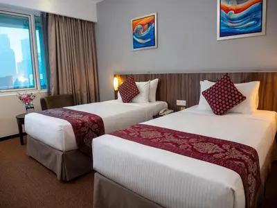 a hotel room with two beds and a window at Hotel Royal Kuala Lumpur in Kuala Lumpur