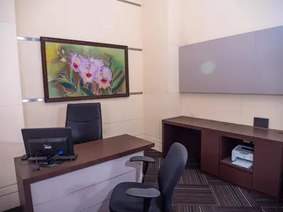 an office with a desk and two chairs and a laptop at Hotel Royal Kuala Lumpur in Kuala Lumpur