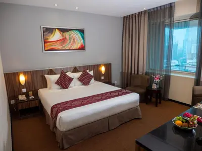 a hotel room with a large bed and a table at Hotel Royal Kuala Lumpur in Kuala Lumpur
