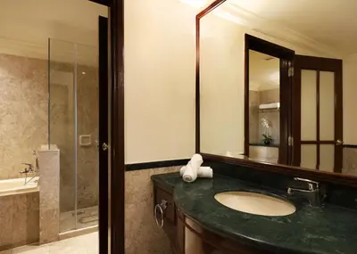 a bathroom with a sink and a mirror and a tub at Berjaya Times Square Hotel, Kuala Lumpur in Kuala Lumpur