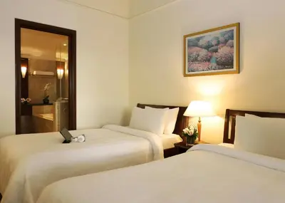 a hotel room with two beds and a mirror at Berjaya Times Square Hotel, Kuala Lumpur in Kuala Lumpur